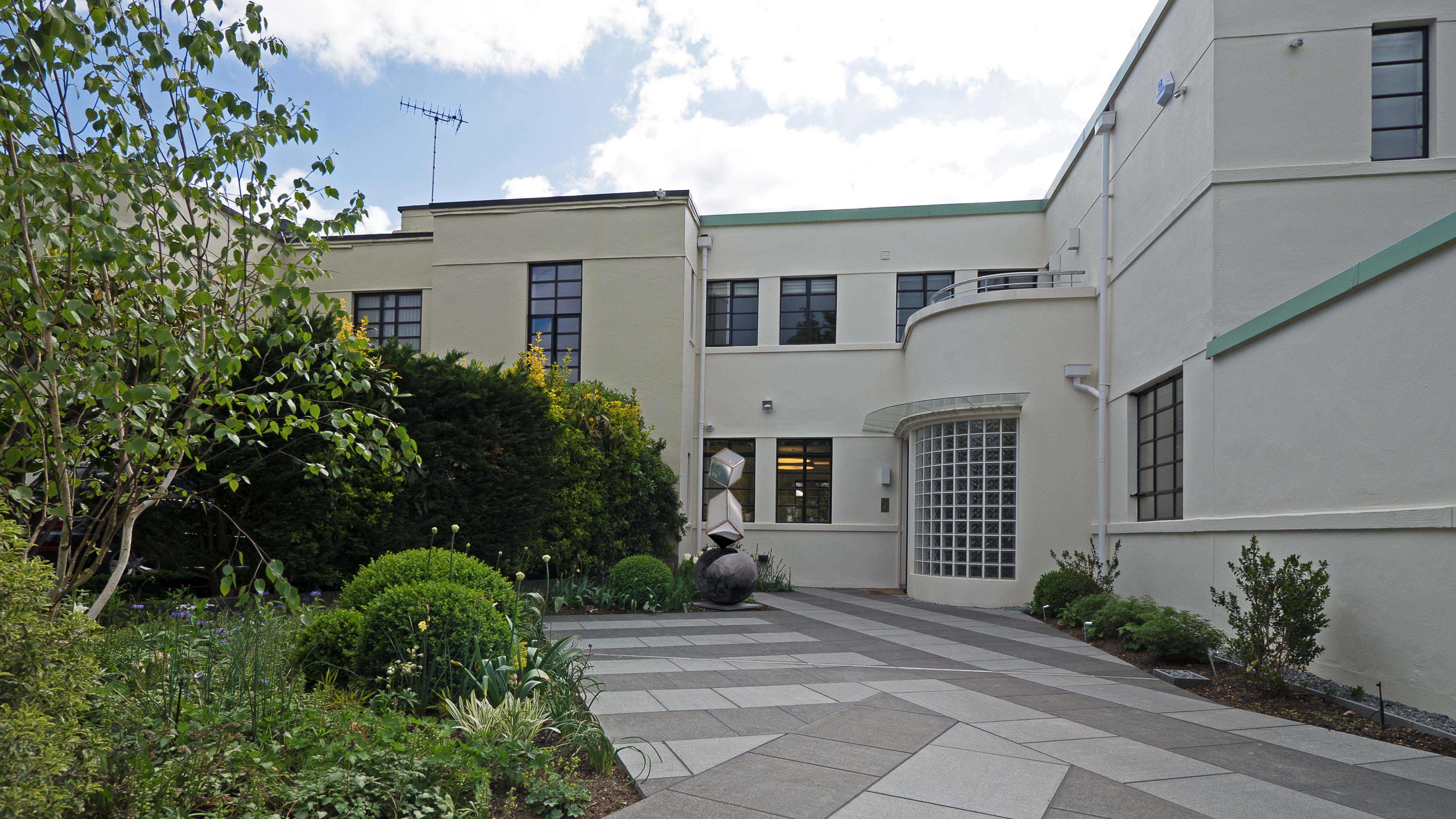 Front elevation of an Art Deco house with curved metal windows and entrance after renovation, Putney Heath