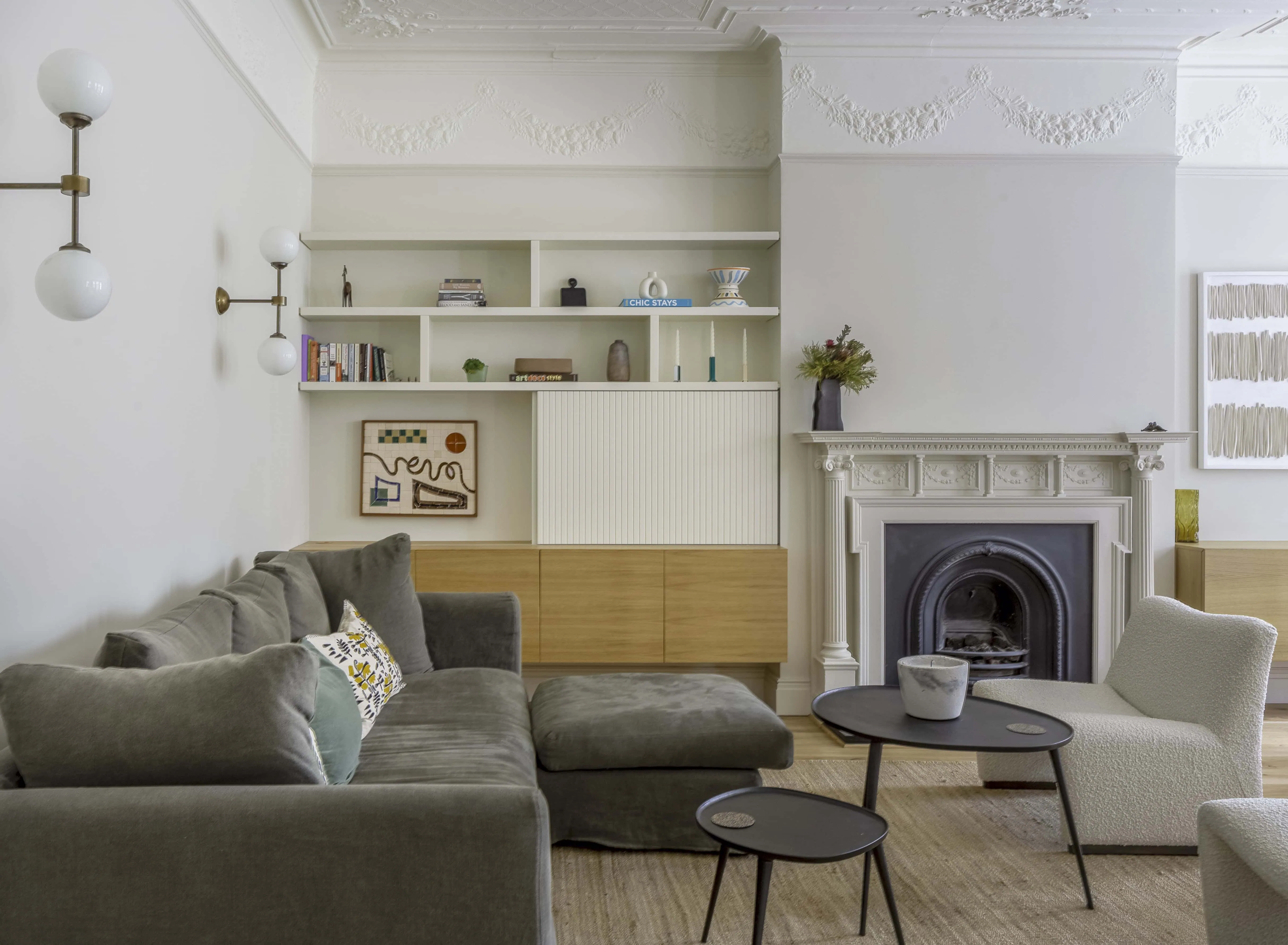 Open-plan living area with fireplace and bespoke joinery in Belsize Park flat