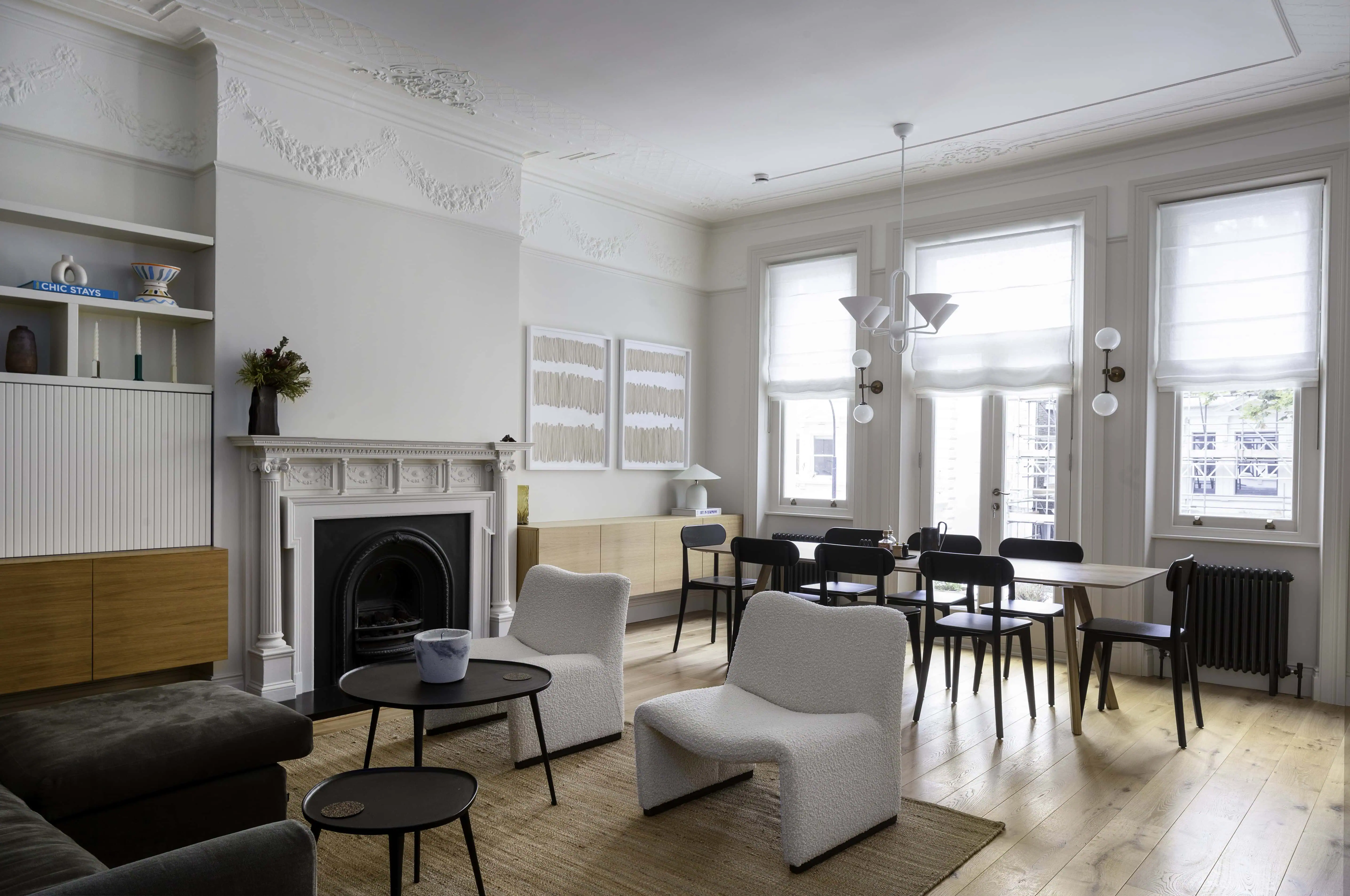 Open-plan living and dining area with fireplace and garden aspect in Belsize Park flat