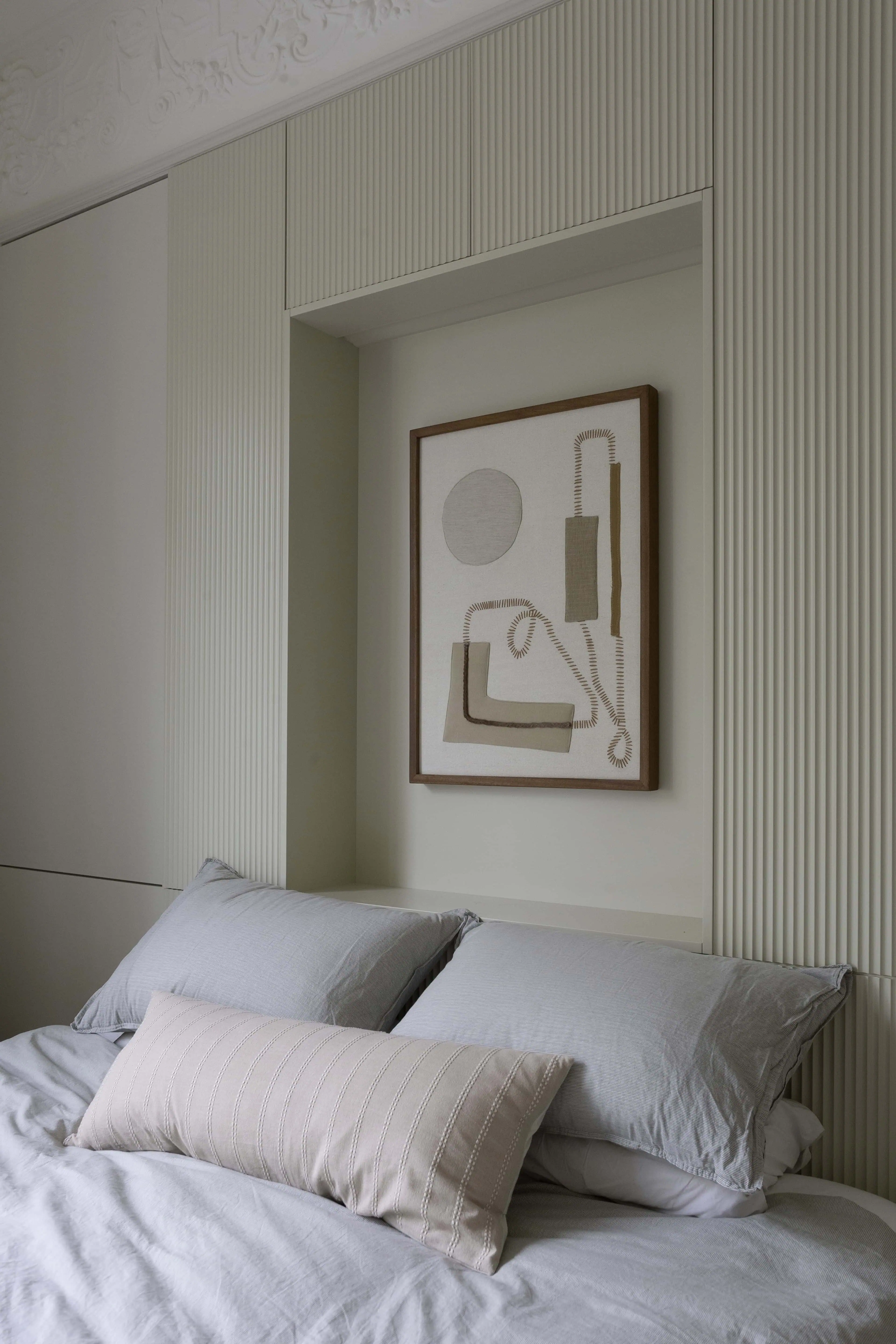 Principal bedroom in a Belsize Park Victorian flat, featuring original ceiling heights, soft textiles, and preserved cornicing
