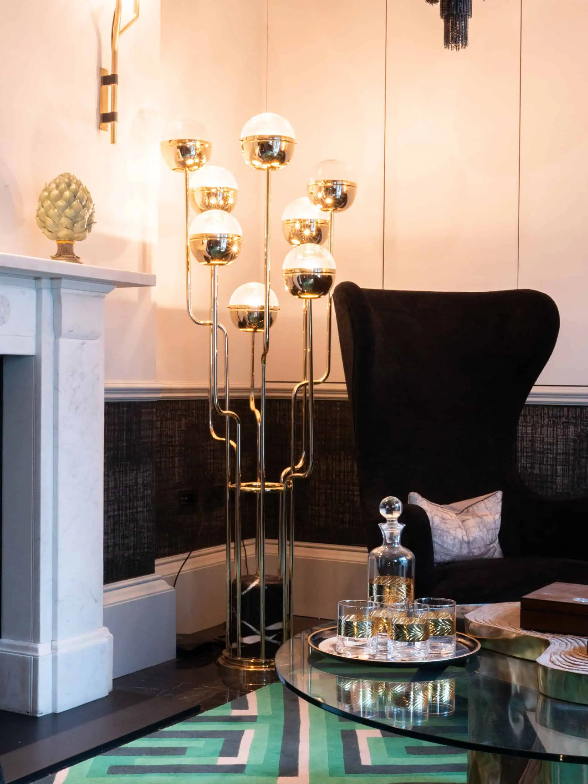 Library space with fireplace setting accented with gold lighting and chic furnishings.