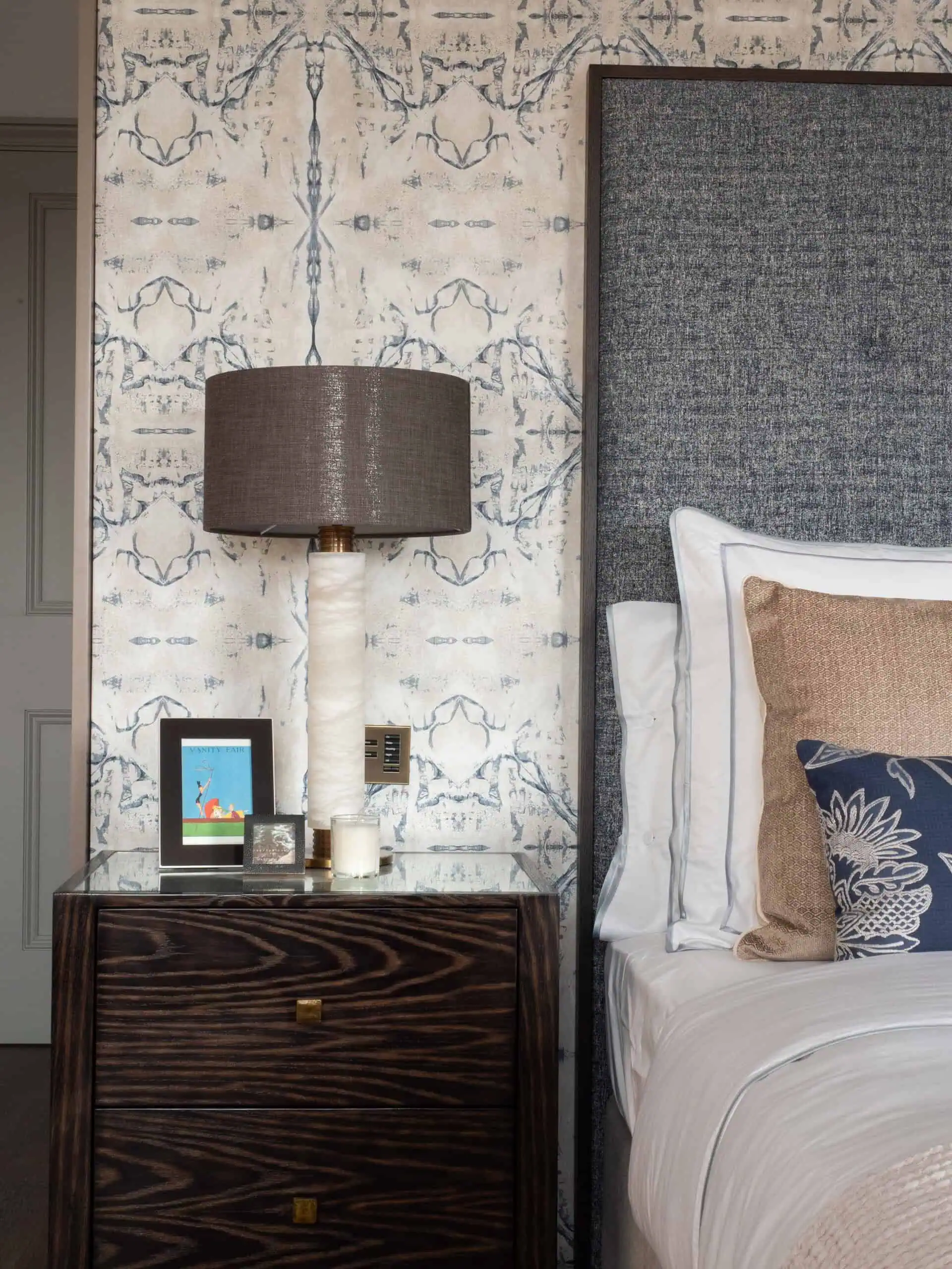 Cozy bedroom corner with textured wall finishes and layered lighting.