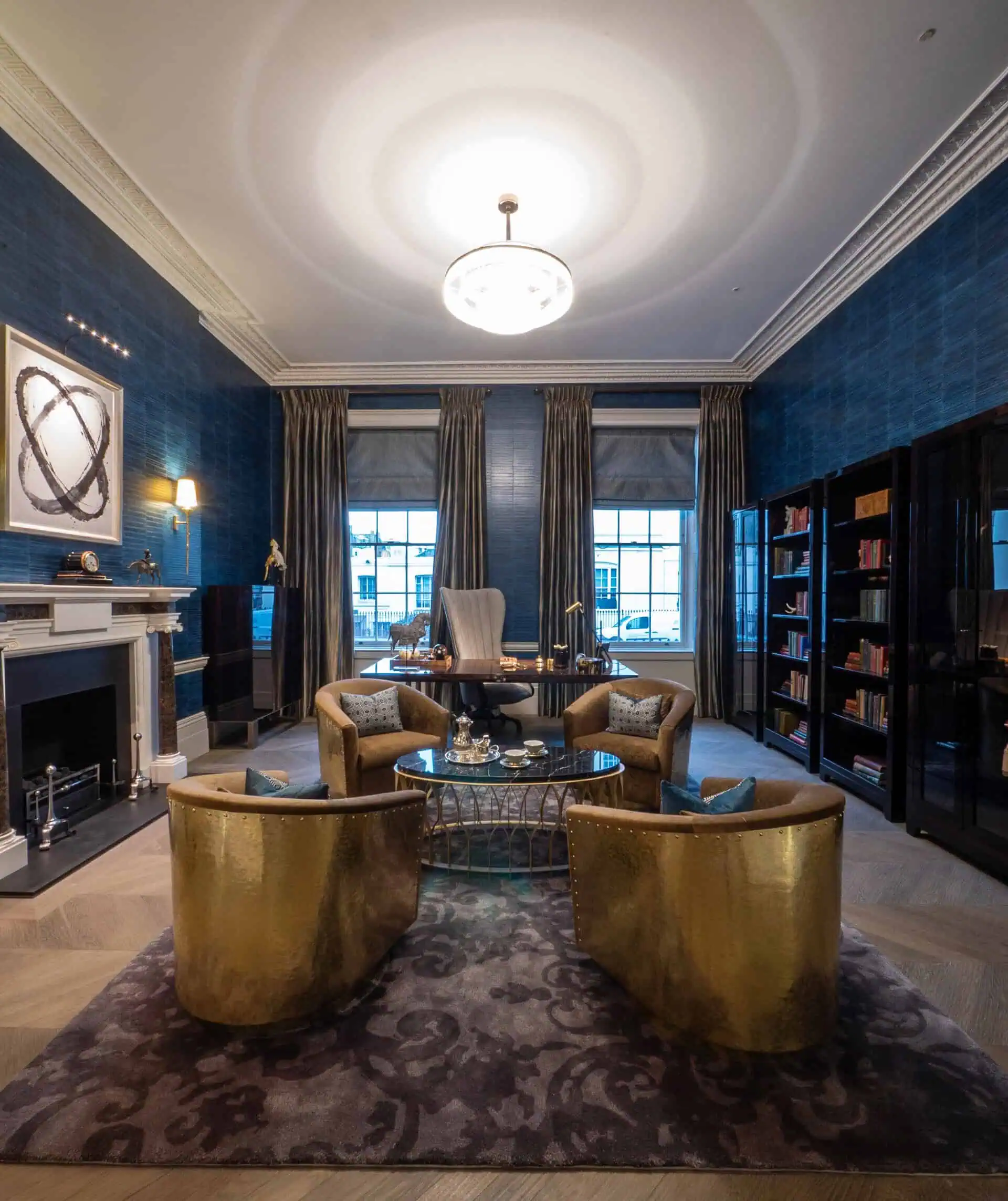 Sophisticated formal lounge with dark tones, brass accents, and statement lighting.