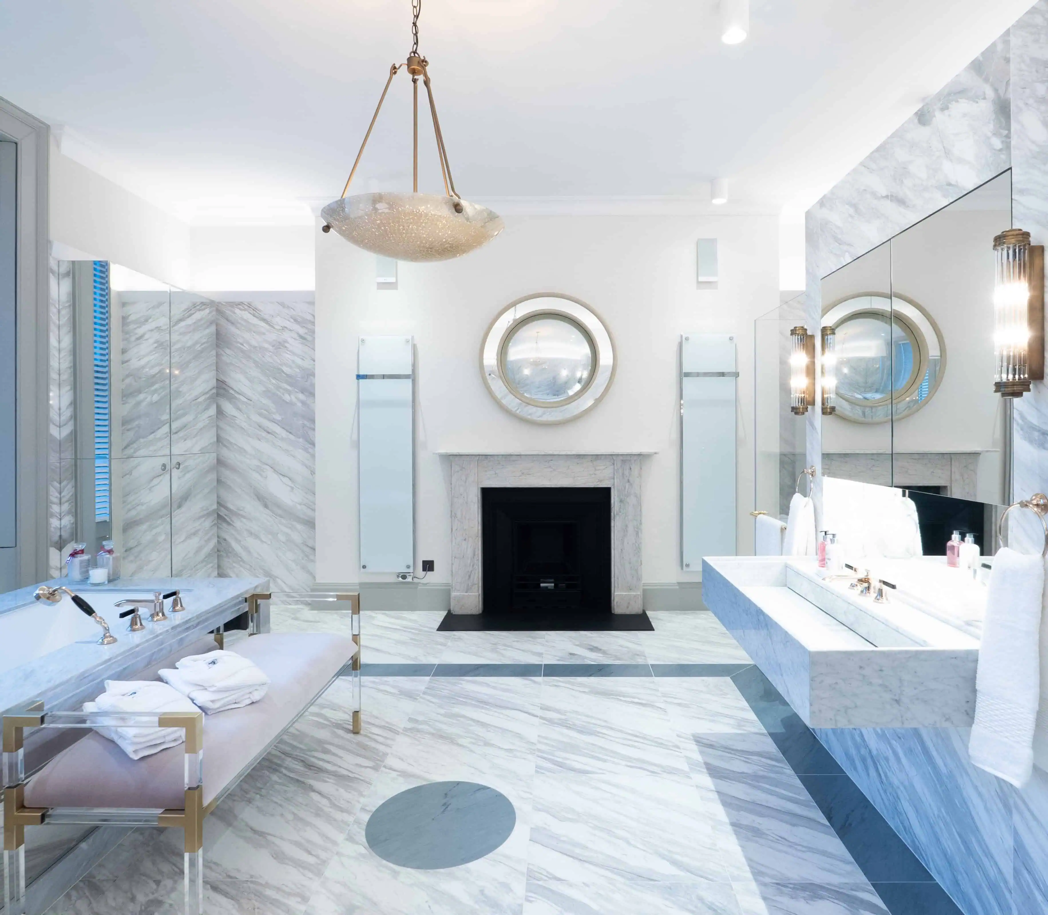 Spa-style marble bathroom with freestanding tub and refined architectural symmetry.