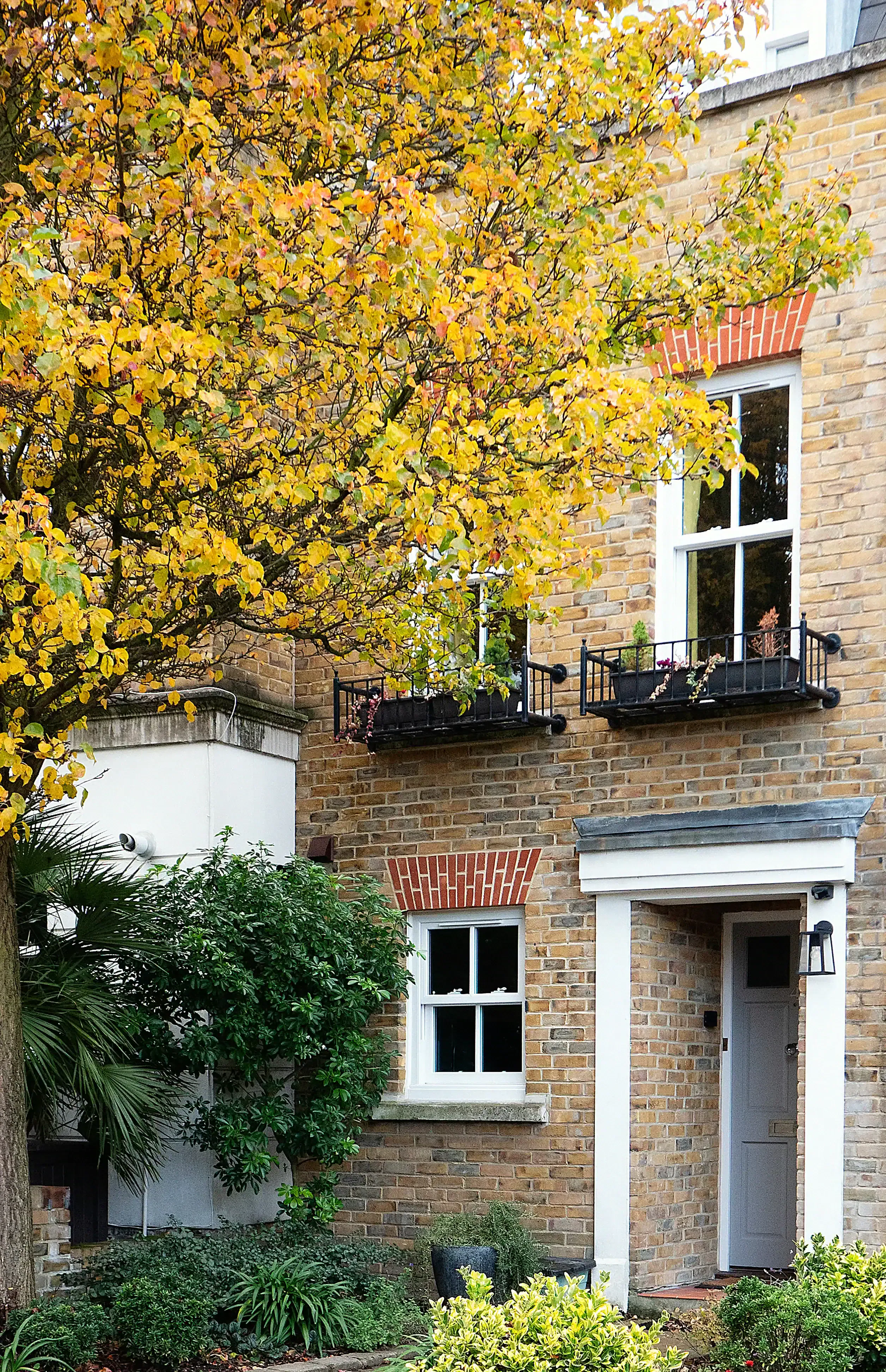 Brick façade of a 1990s mews house in Belsize Park, North London, in autumn.