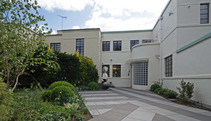 Front elevation of an Art Deco house with curved metal windows and entrance after renovation, Putney Heath